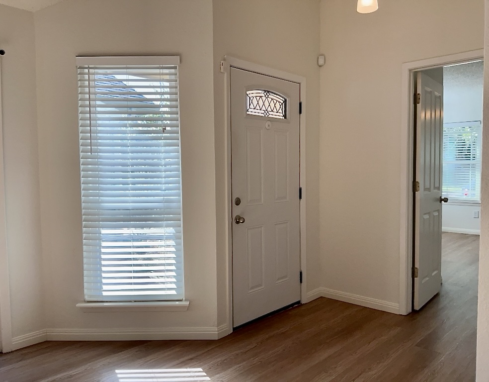 16912 Village Oak Loop Austin, TX 78717 - Photo 3 of 15 a view of an empty room with wooden floor and a window