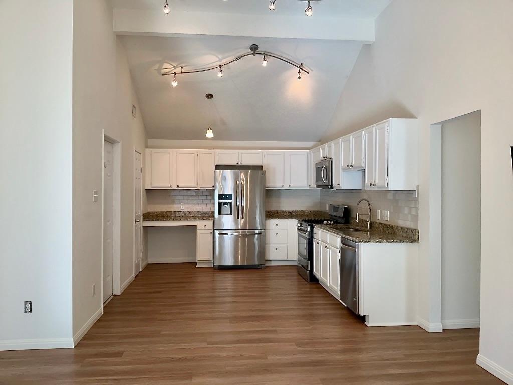 16912 Village Oak Loop Austin, TX 78717 - Photo 6 of 15 a kitchen with granite countertop a refrigerator and a stove top oven