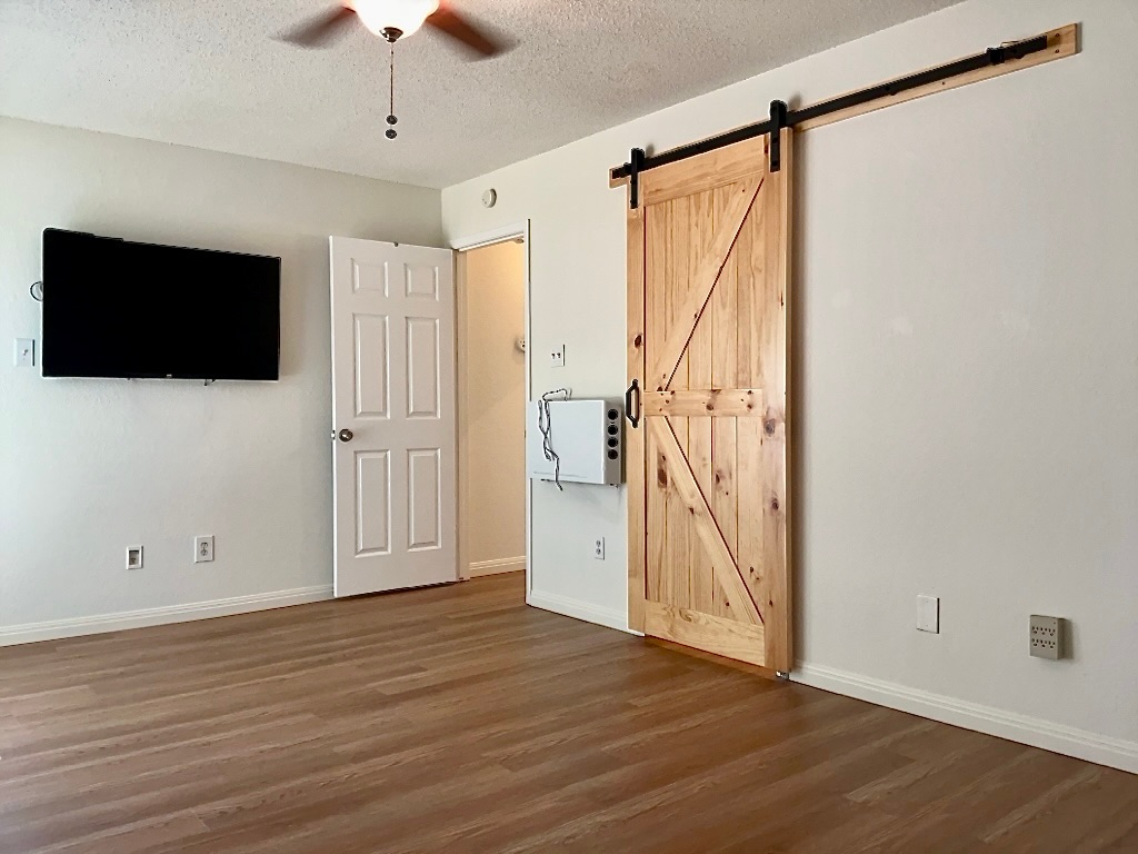 16912 Village Oak Loop Austin, TX 78717 - Photo 8 of 15 a view of an empty room with wooden floor and a window