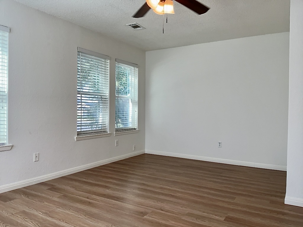 16912 Village Oak Loop Austin, TX 78717 - Photo 10 of 15 a view of an empty room with wooden floor and a window
