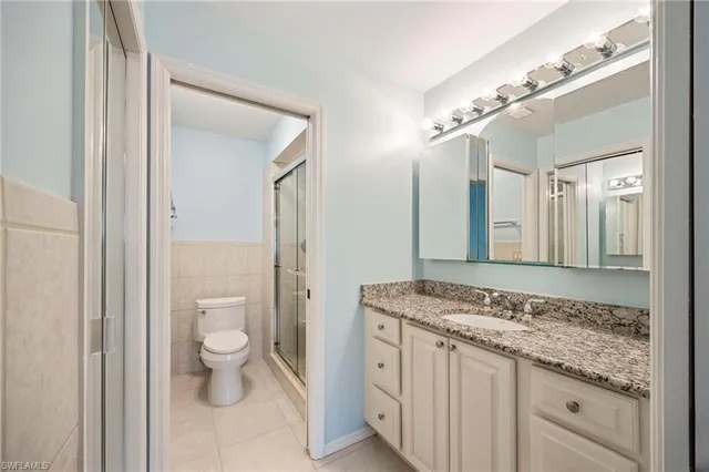 a spacious bathroom with a granite countertop sink and a mirror