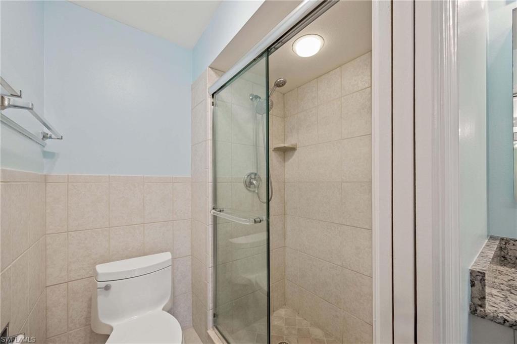 1608 Spoonbill Lane, Unit B Naples, FL 34105 - Photo 12 of 31 a bathroom with a toilet and shower