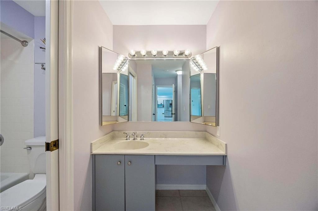 1608 Spoonbill Lane, Unit B Naples, FL 34105 - Photo 14 of 31 a bathroom with a sink and a mirror