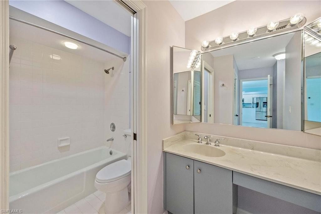 1608 Spoonbill Lane, Unit B Naples, FL 34105 - Photo 15 of 31 a bathroom with a bathtub shower sink vanity and toilet