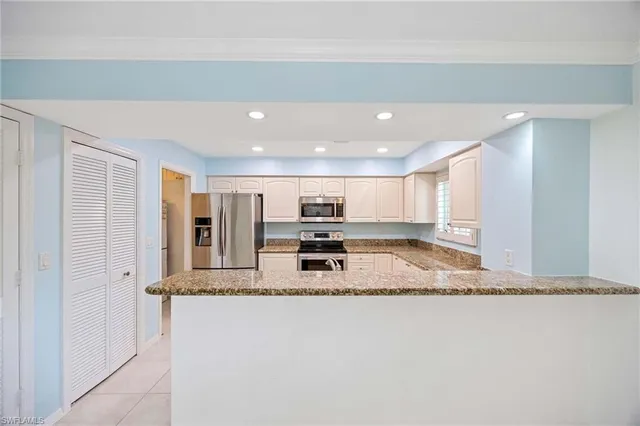 a view of kitchen with stainless steel appliances granite countertop refrigerator sink and stove