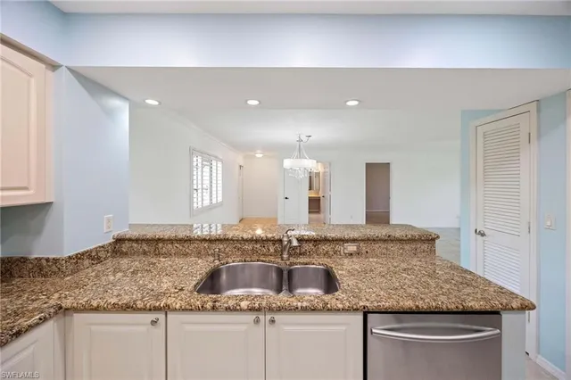 a bathroom with a granite countertop double vanity and a mirror