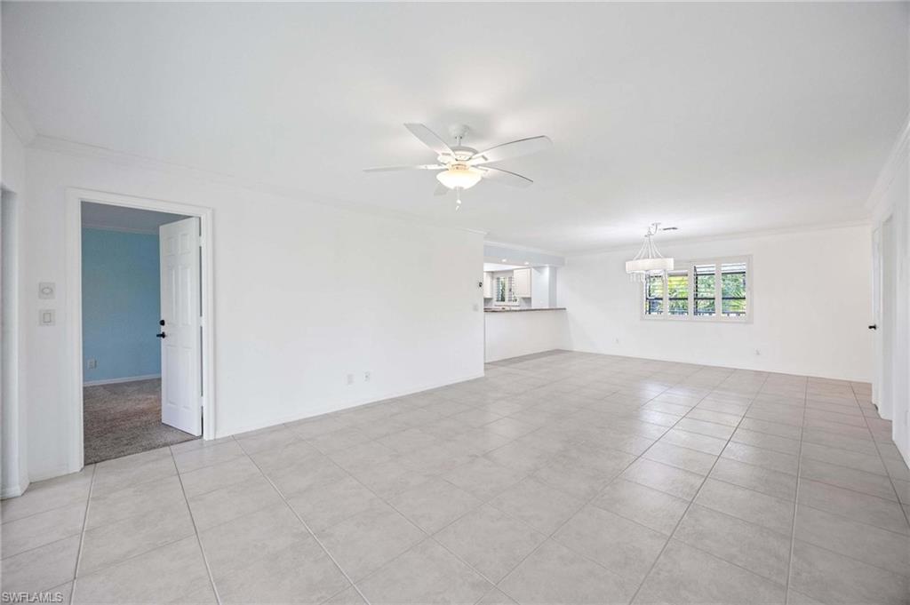 1608 Spoonbill Lane, Unit B Naples, FL 34105 - Photo 7 of 31 an empty room with windows and fan