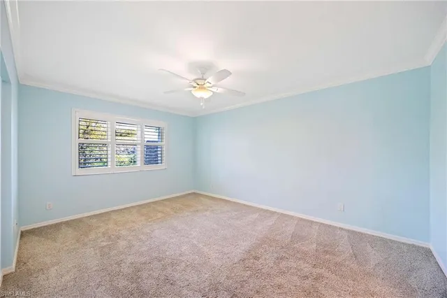 an empty room with windows and chandelier fan