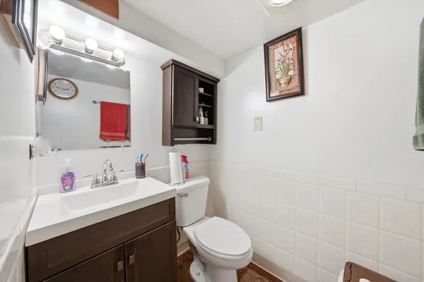 a bathroom with a toilet sink vanity and mirror