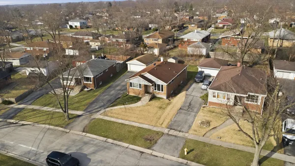 an aerial view of residential houses with yard