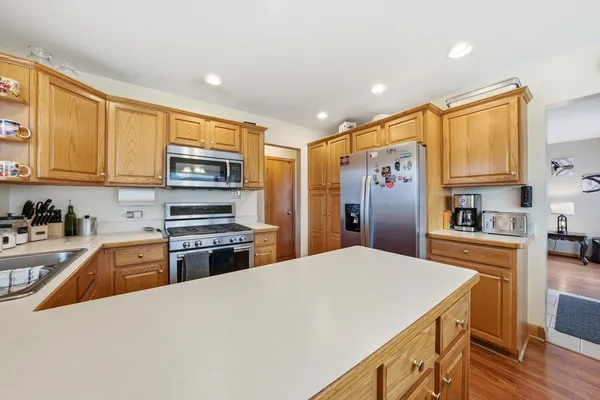 a kitchen with stainless steel appliances granite countertop a sink stove microwave and refrigerator