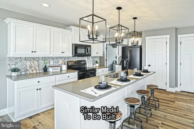 a kitchen with stainless steel appliances a sink a stove a table and chairs