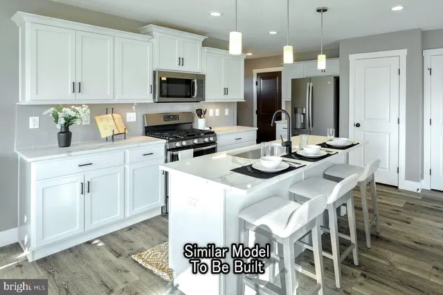 a kitchen with stainless steel appliances kitchen island granite countertop a stove a sink a refrigerator and a microwave