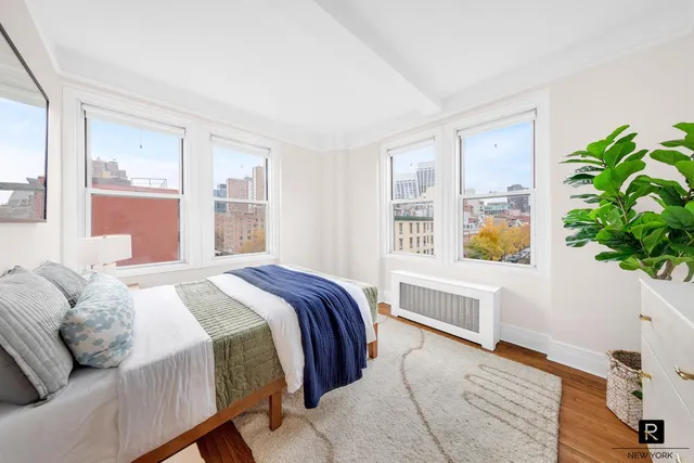 a bedroom with a bed and a lamp next to a window