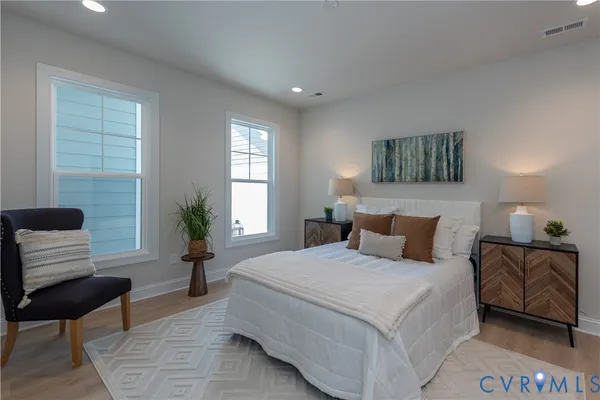 a bedroom with a bed a couch and a potted plant