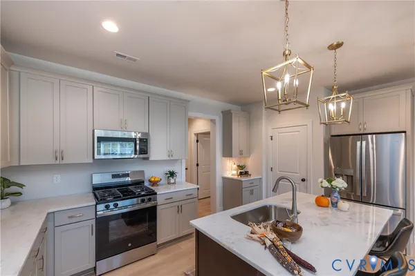 a kitchen with kitchen island granite countertop a sink appliances and cabinets