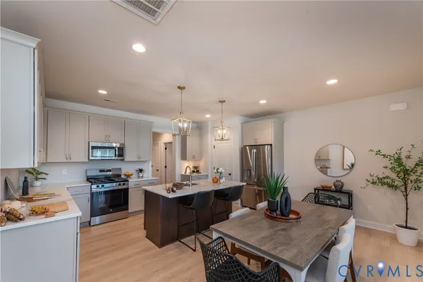 a kitchen with a refrigerator a stove top oven a sink and cabinets