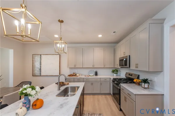 a kitchen with stainless steel appliances granite countertop a sink dishwasher stove top oven and cabinets with wooden floor