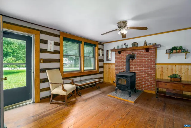 a living room with furniture a fireplace and a floor to ceiling window