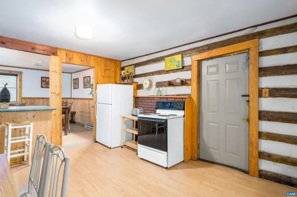 a kitchen with a refrigerator and wooden floor