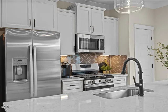 a kitchen with stainless steel appliances granite countertop a refrigerator and a stove top oven