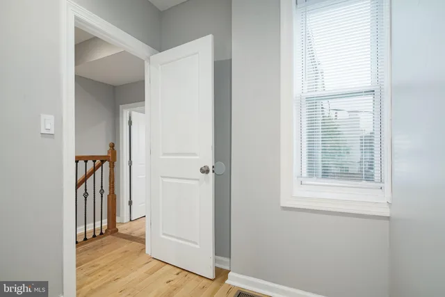 a view of a hallway with wooden floor and a window