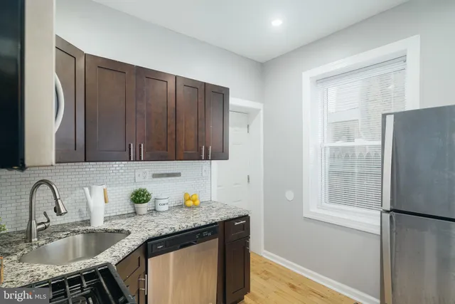 a kitchen with stainless steel appliances granite countertop a sink refrigerator and cabinets