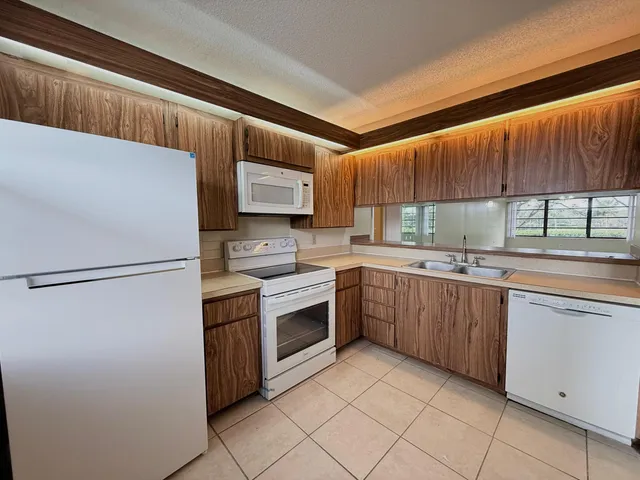 a kitchen with a refrigerator sink and cabinets