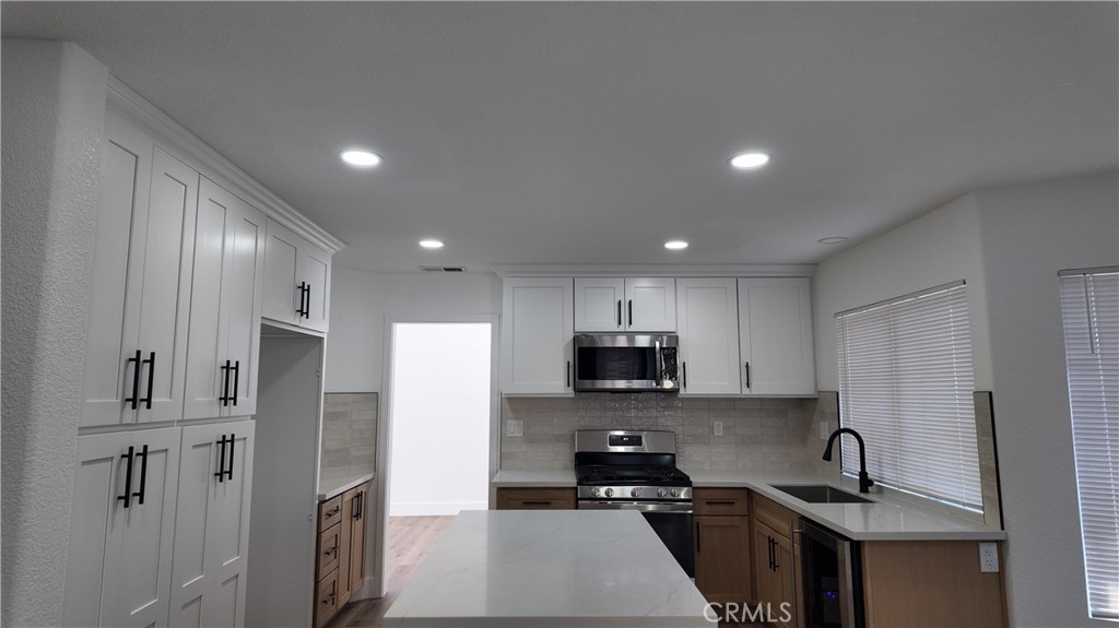 21484 Dickinson Road Moreno Valley, CA 92557 - Photo 4 of 10 a kitchen with stainless steel appliances a refrigerator sink and stove