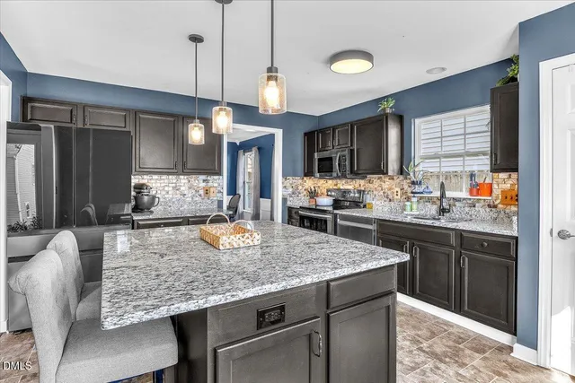 a kitchen with granite countertop kitchen island a stove and a sink