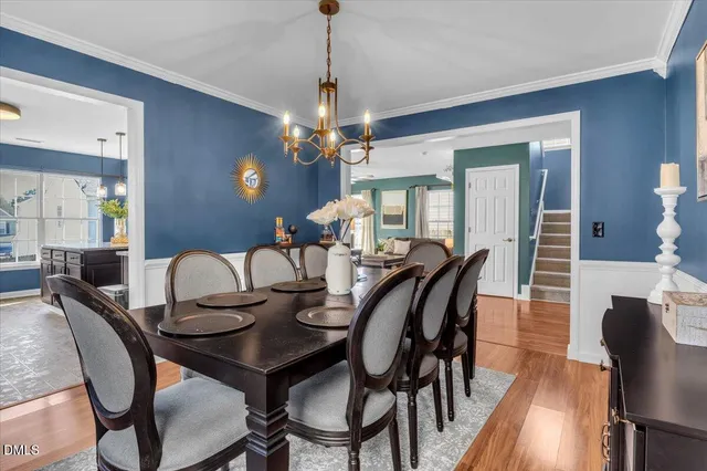a bedroom with a bed chandelier painting on the wall and a lamp