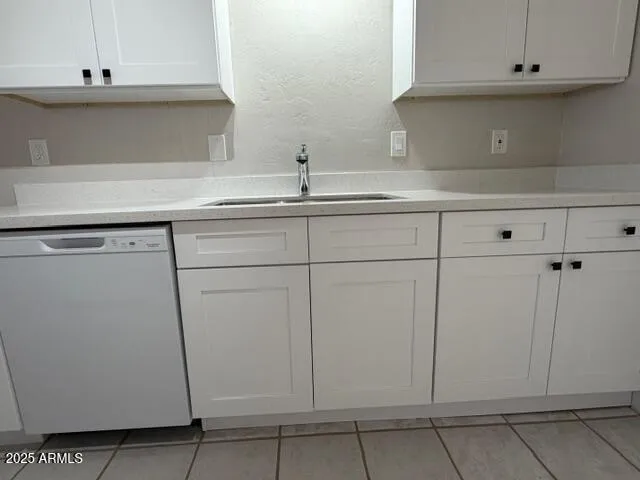 a kitchen with white cabinets and a sink
