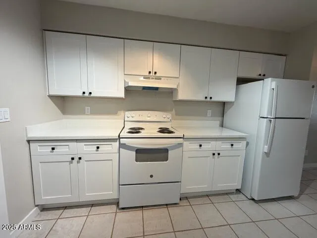 a kitchen with white cabinets and white appliances