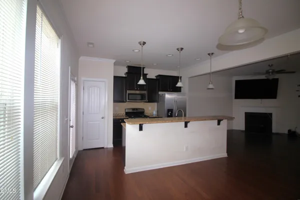a view of kitchen with stainless steel appliances kitchen island refrigerator stove and microwave