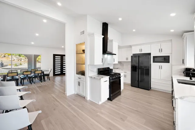 a kitchen with stainless steel appliances kitchen island granite countertop a refrigerator and a stove top oven