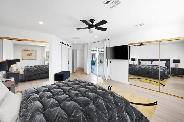 a bedroom with furniture and a flat screen tv