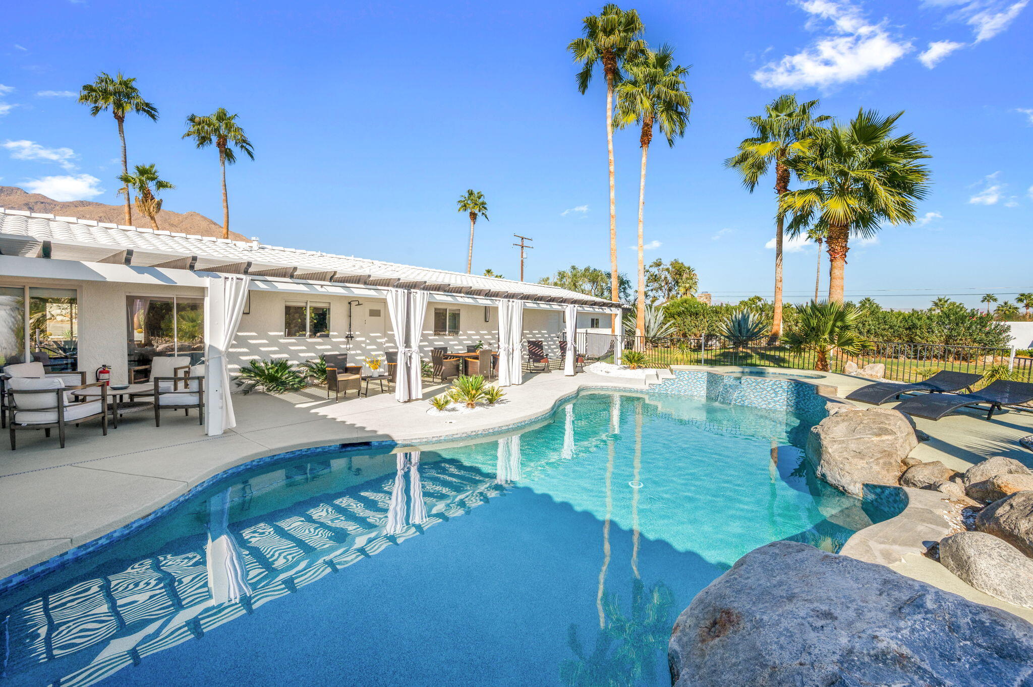 2380 North Leonard Road Palm Springs, CA 92262 - Photo 42 of 54 a view of a swimming pool with a table and chairs