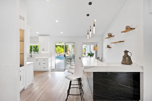 a kitchen with stainless steel appliances a stove a table and cabinets