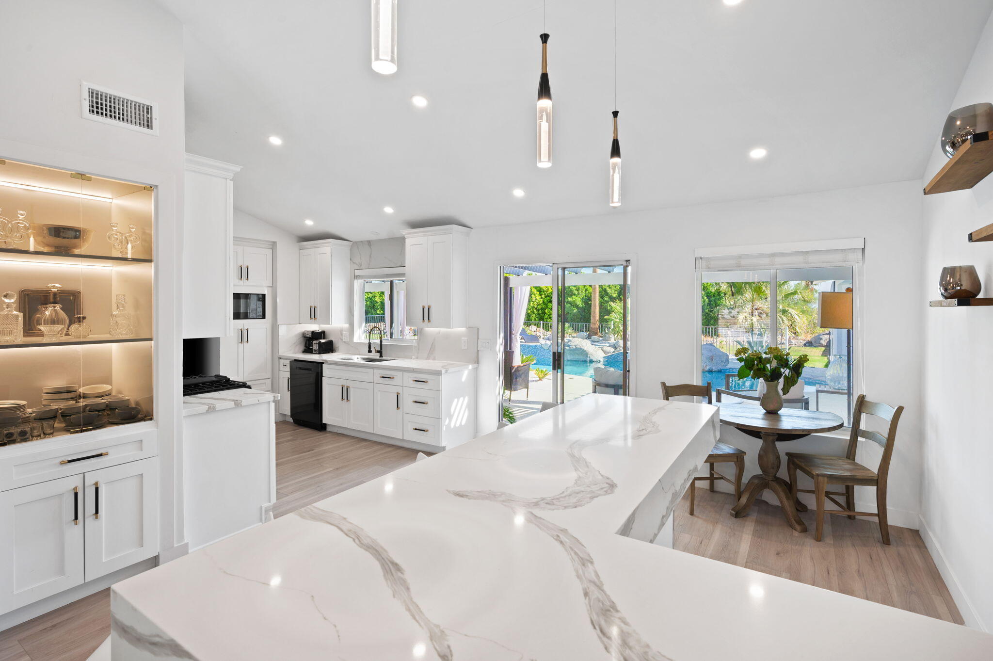 2380 North Leonard Road Palm Springs, CA 92262 - Photo 6 of 54 a large white kitchen with stainless steel appliances kitchen island granite countertop a sink and cabinets