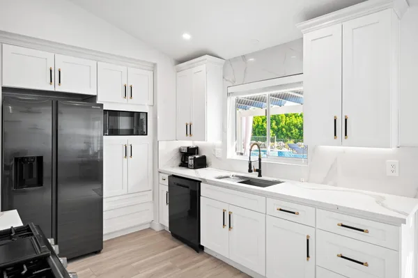 a kitchen with a sink stainless steel appliances and window
