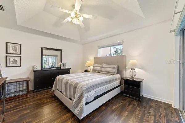 a bedroom with a bed wooden floor and window