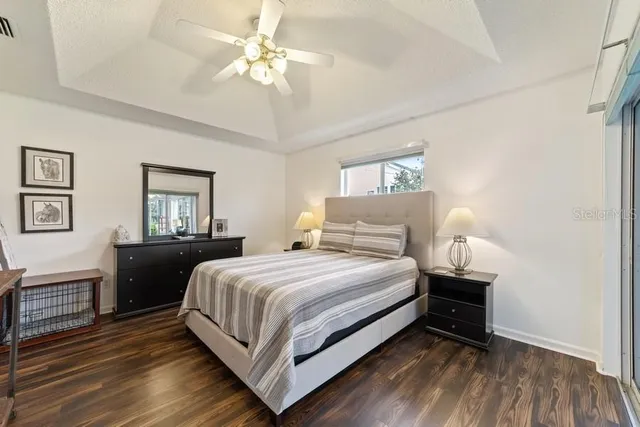 a bedroom with a bed wooden floor and window