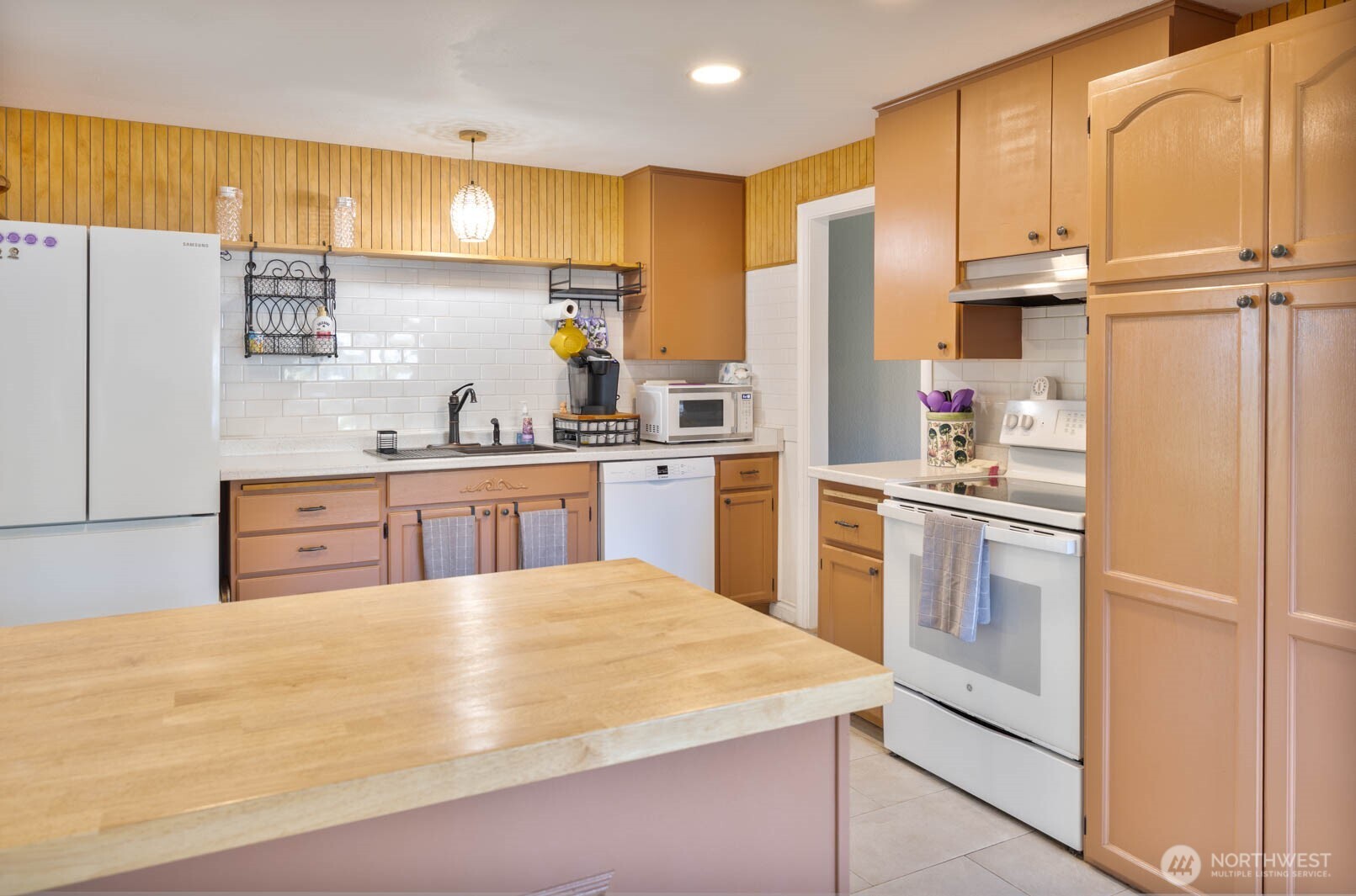 6028 South Prospect Street Tacoma, WA 98409 - Photo 9 of 32 a kitchen with kitchen island sink refrigerator and cabinets