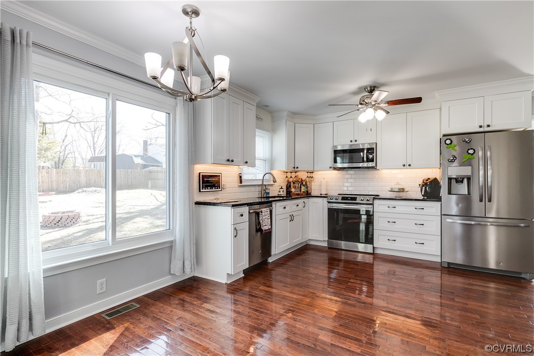 10811 Crofton Road Chester, VA 23831 - Photo 23 of 50 a kitchen with stainless steel appliances granite countertop a refrigerator a sink dishwasher a stove and white cabinets with wooden floor