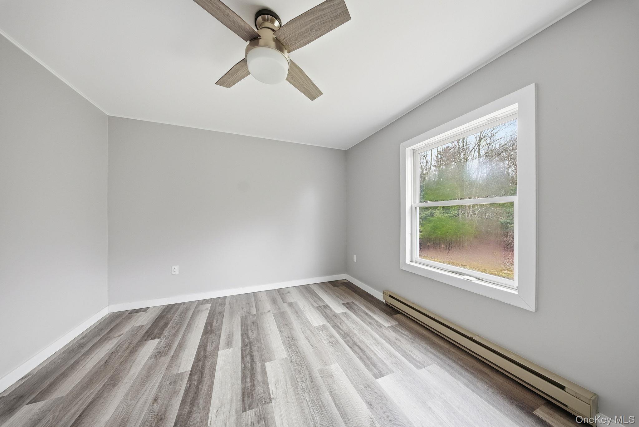 39 Dingle Daisy Road Monticello, NY 12701 - Photo 14 of 36 wooden floor in an empty room with a window
