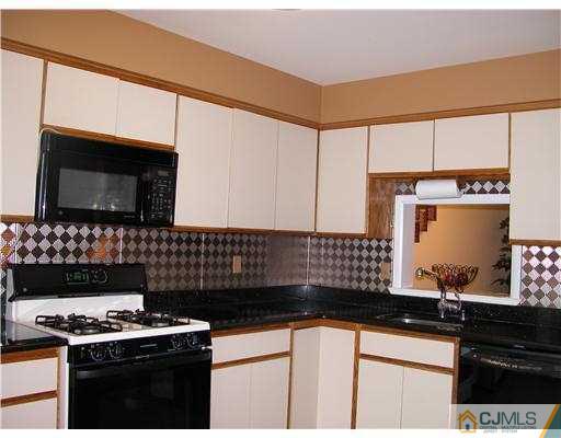 3903 Springbrook Drive Edison, NJ 08820 - Photo 4 of 11 a kitchen with stainless steel appliances a stove and a microwave