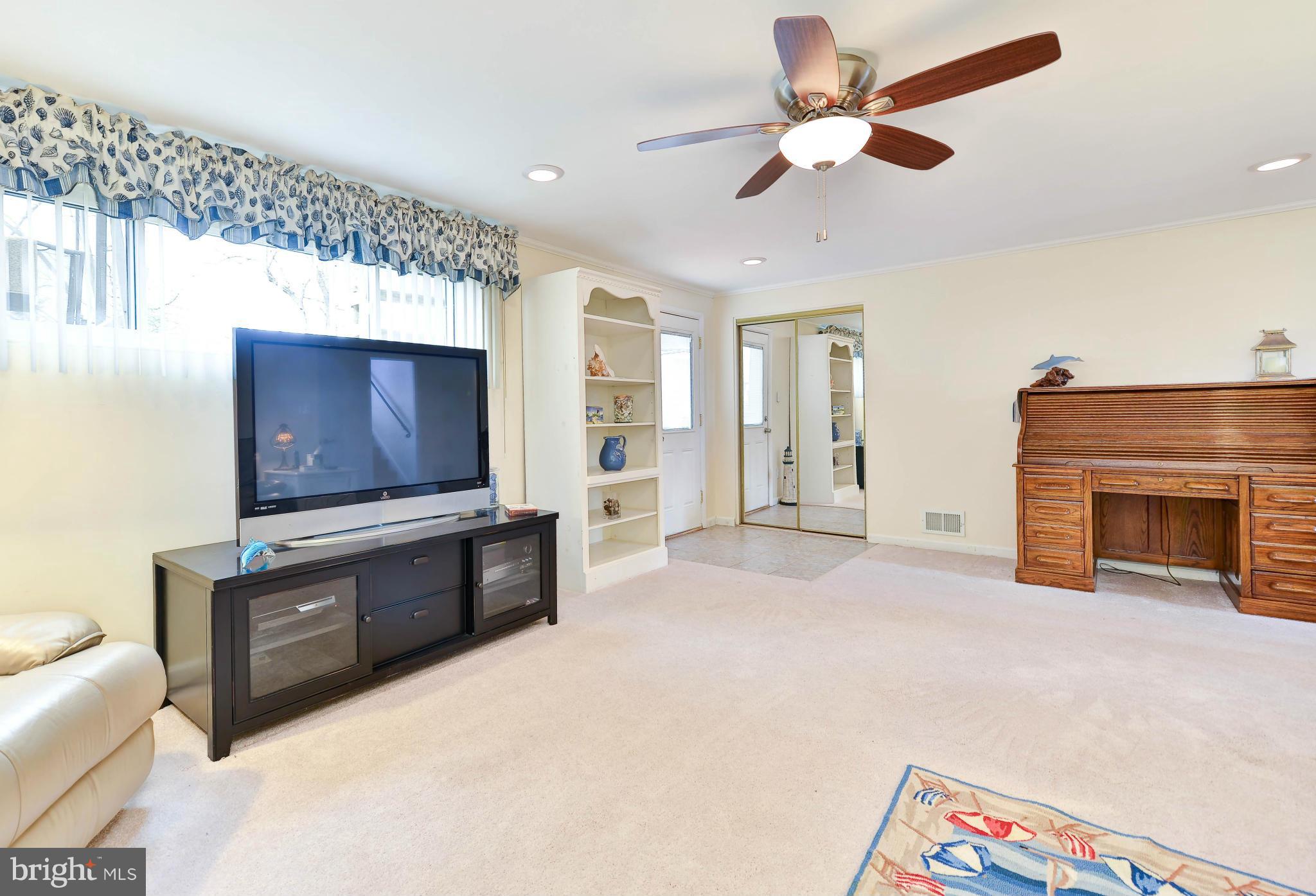 8504 Wagon Wheel Road Alexandria, VA 22309 - Photo 19 of 30 a view of an empty room with a fireplace and a ceiling fan