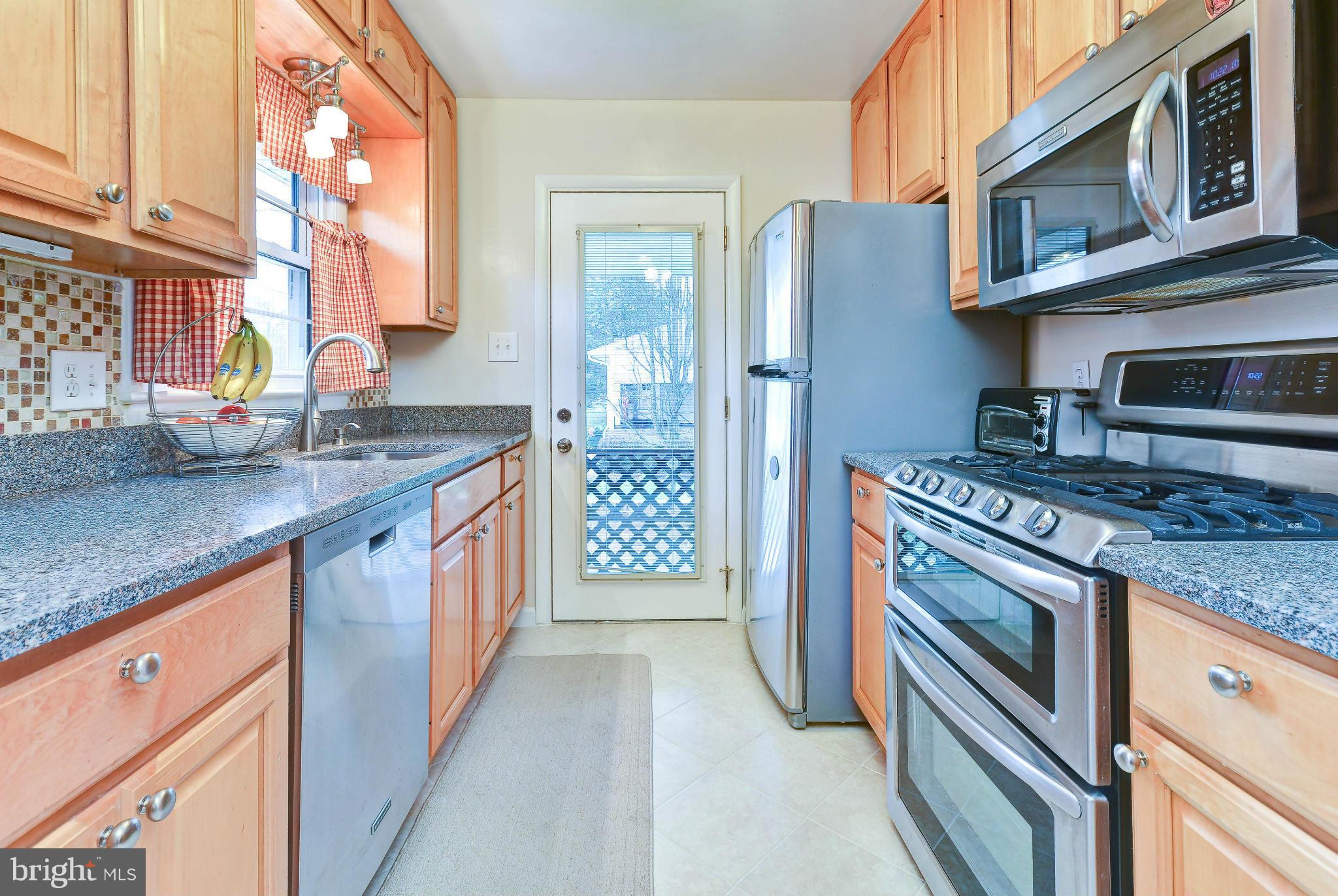 8504 Wagon Wheel Road Alexandria, VA 22309 - Photo 4 of 30 a kitchen with stainless steel appliances granite countertop a stove and a sink