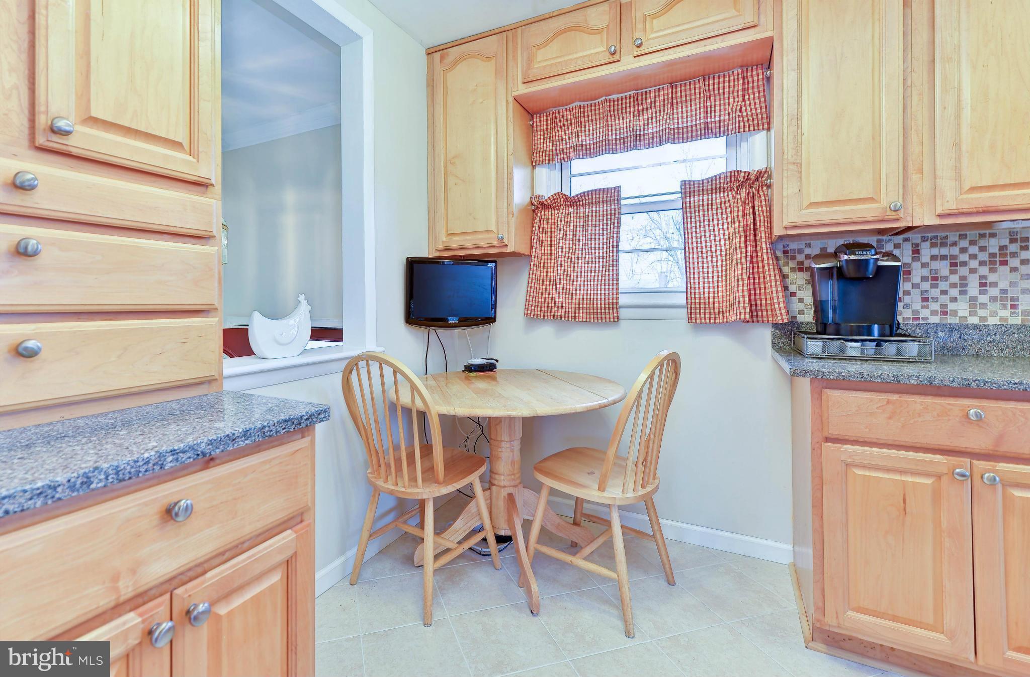 8504 Wagon Wheel Road Alexandria, VA 22309 - Photo 5 of 30 a kitchen with granite countertop a table chairs stove and cabinets