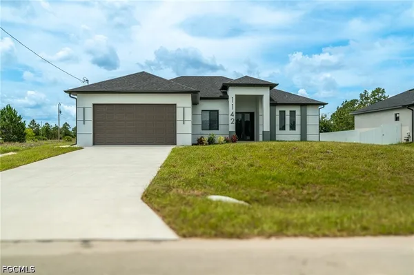 a front view of a house with a yard and garage